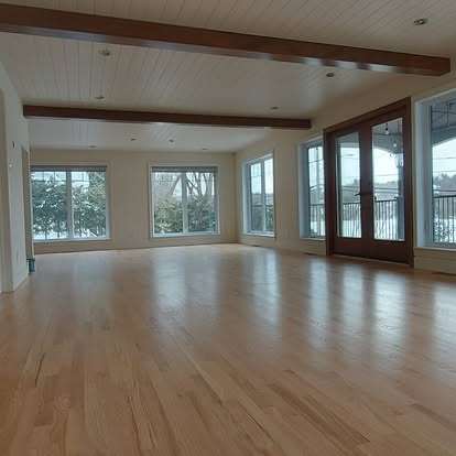 Grand salon lumineux avec poutres apparentes — rénovation peinture Estrie